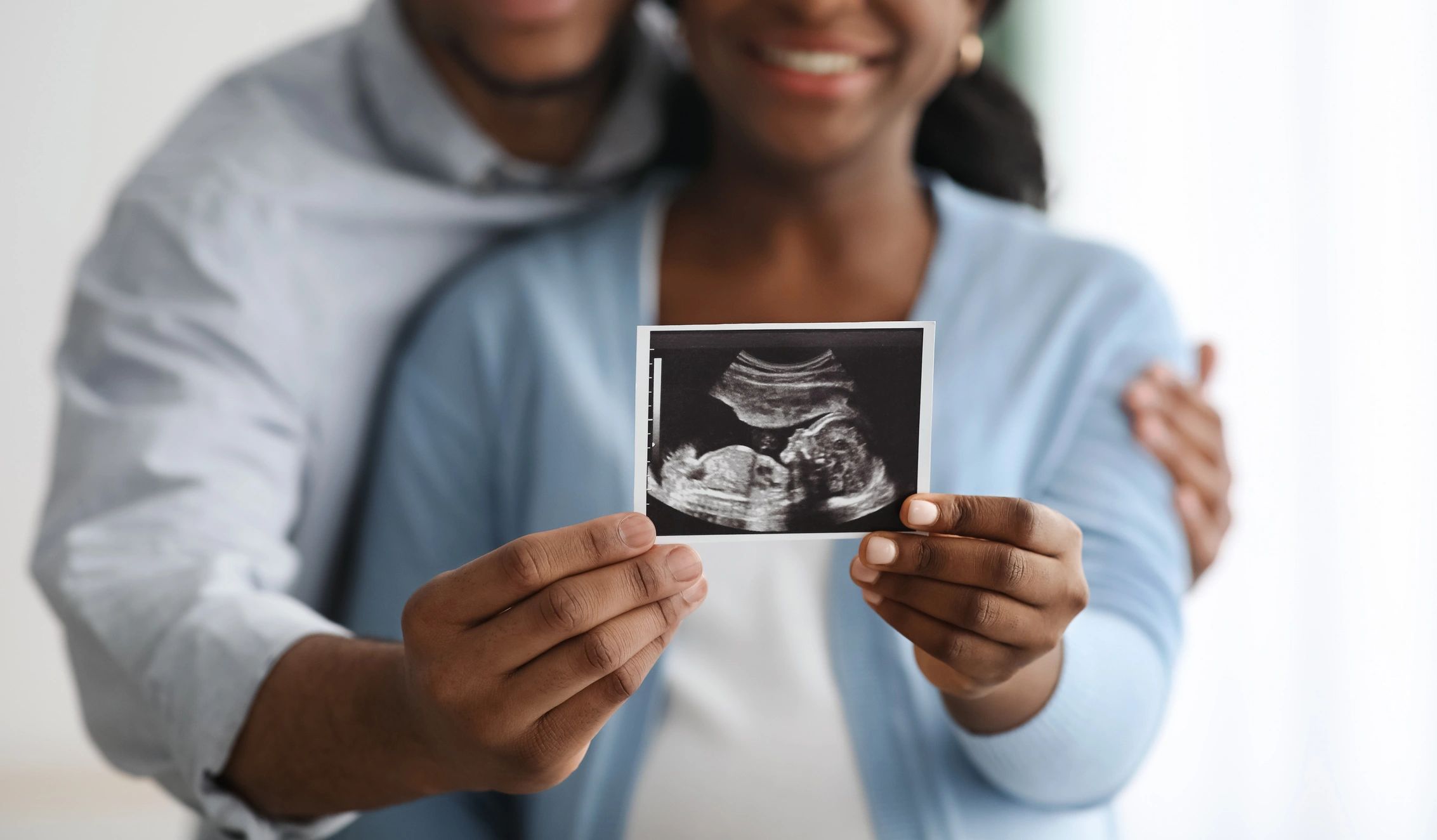 Couple holding a baby sonogram together