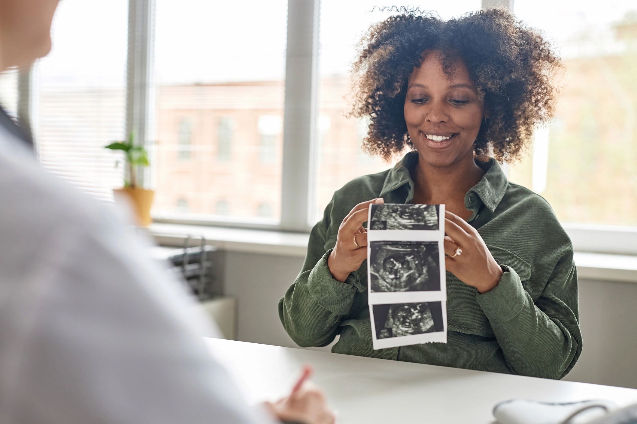 Pregnant woman holding a baby sonogram image